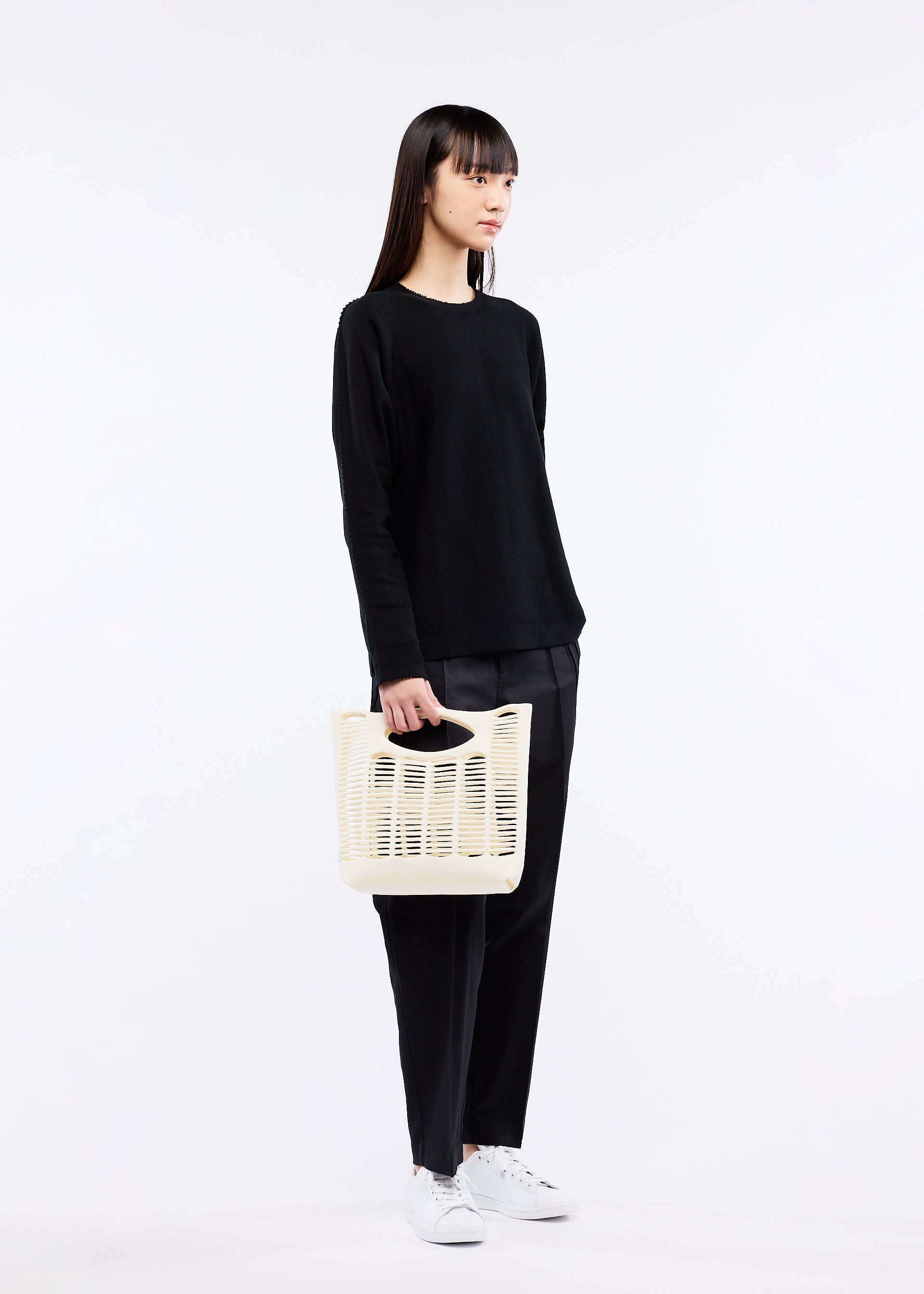 A model wears the GOOD GOODS ISSEY MIYAKE MOKKO bag.