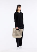 A model wears the GOOD GOODS ISSEY MIYAKE MOKKO bag.