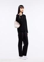 A model wears the GOOD GOODS ISSEY MIYAKE MOKKO FLAP POUCH bag.