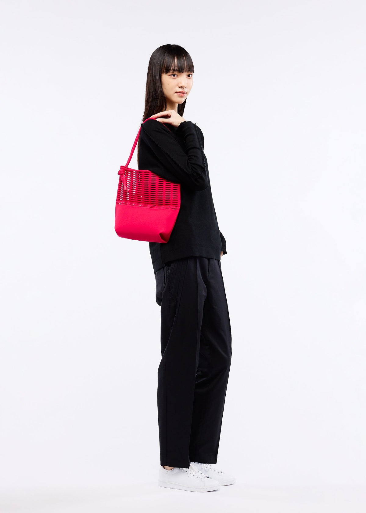 A model wears the GOOD GOODS ISSEY MIYAKE MOKKO FLAP POUCH bag.