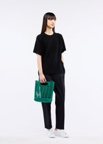 A model wears the GOOD GOODS ISSEY MIYAKE MOKKO S.C. bag.