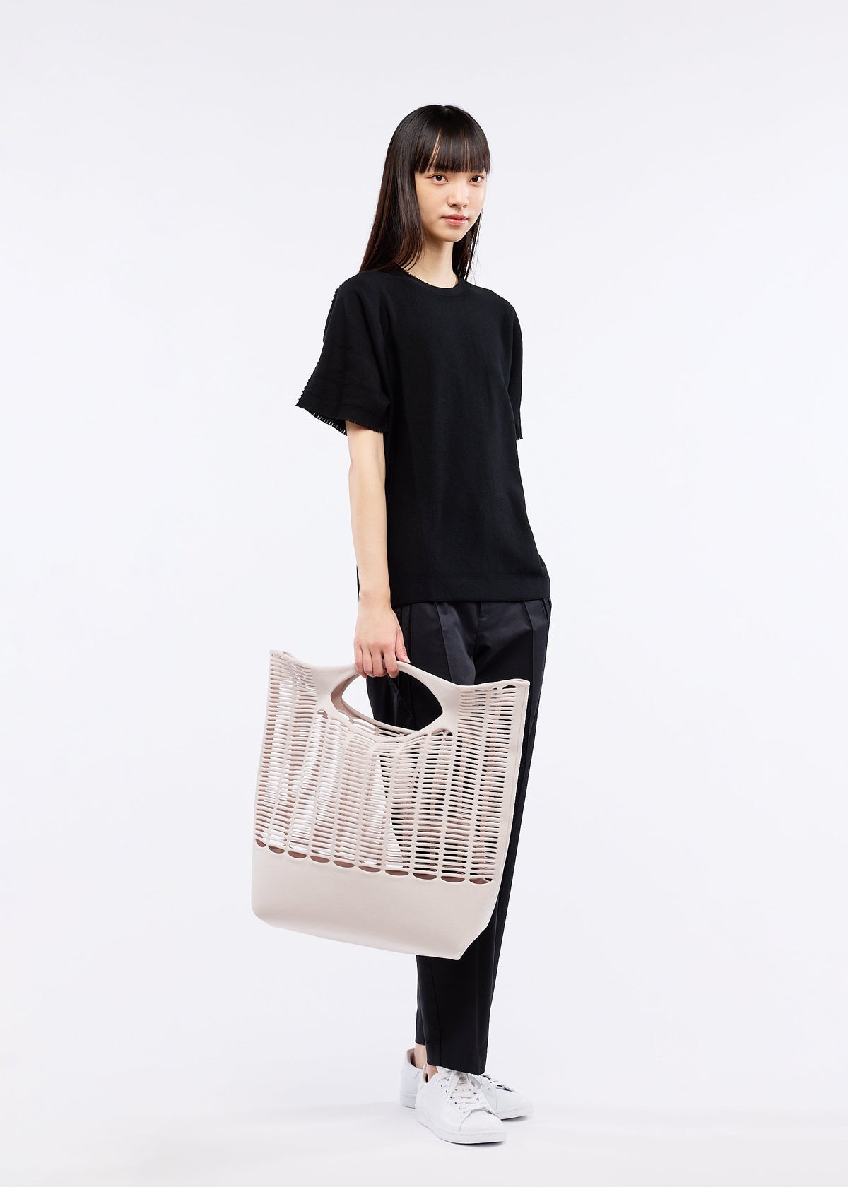 A model wears the GOOD GOODS ISSEY MIYAKE MOKKO S.C. bag.