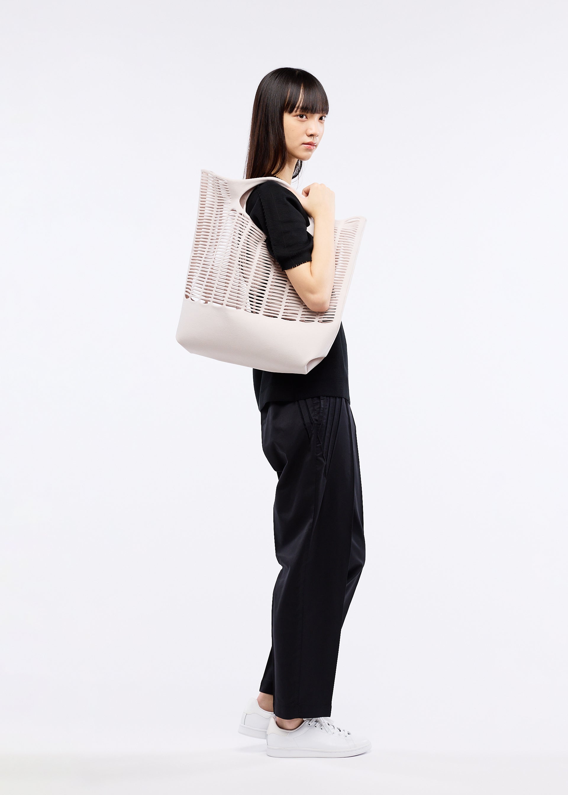 A model wears the GOOD GOODS ISSEY MIYAKE MOKKO S.C. bag.