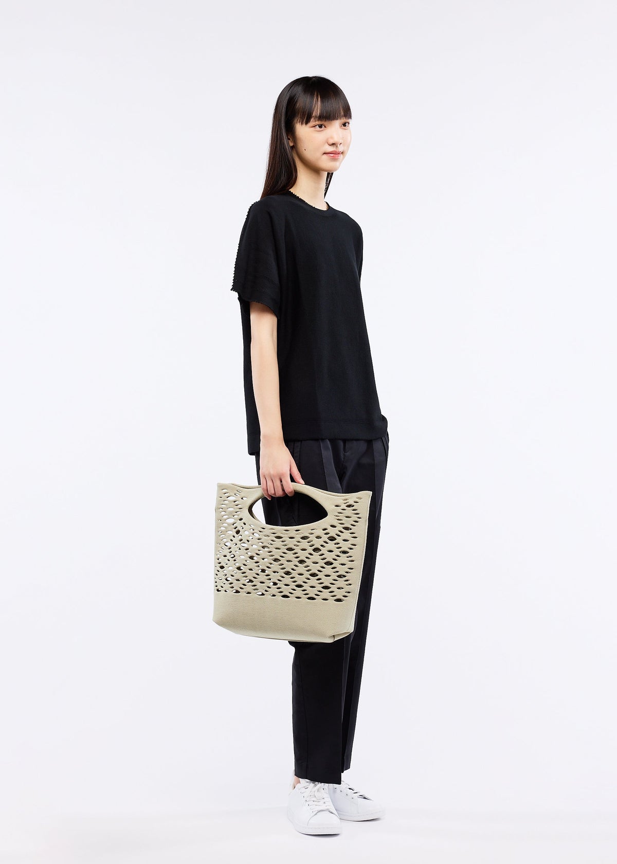 A model wears the GOOD GOODS ISSEY MIYAKE MOKKO BASKET bag.