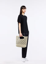 A model wears the GOOD GOODS ISSEY MIYAKE MOKKO BASKET bag.