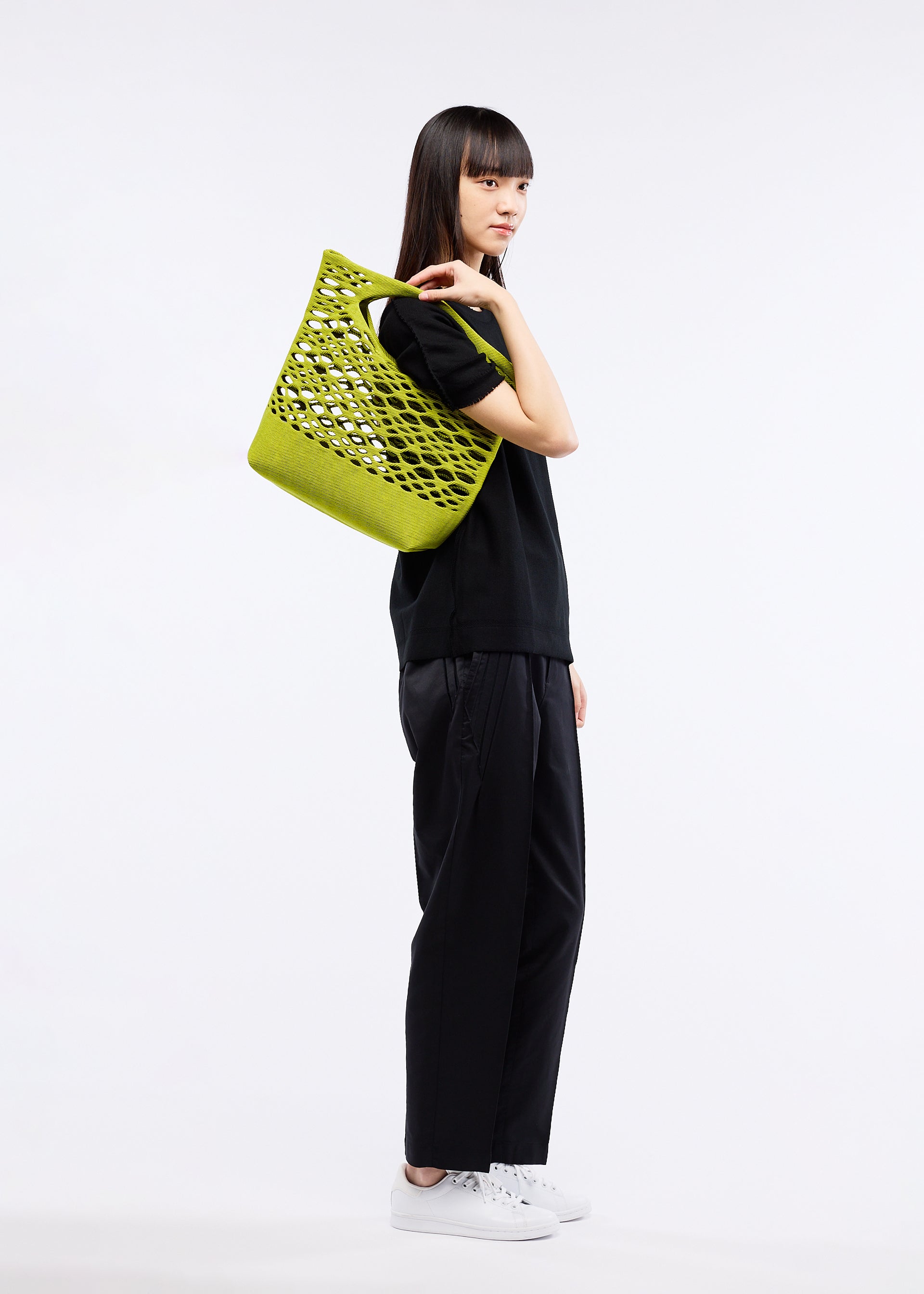 A model wears the GOOD GOODS ISSEY MIYAKE MOKKO BASKET bag.
