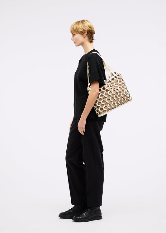 A model wears the GOOD GOODS ISSEY MIYAKE AMIME bag.