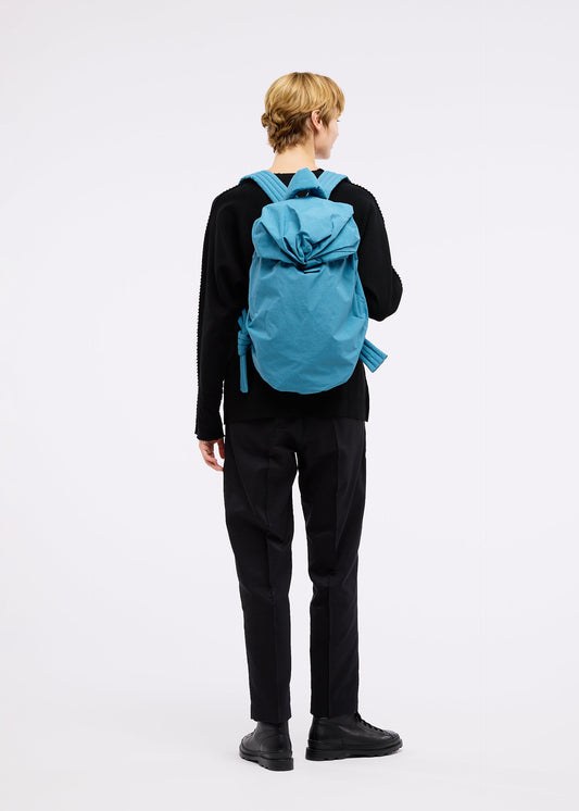 A model wears the GOOD GOODS ISSEY MIYAKE FUWA FUWA bag.