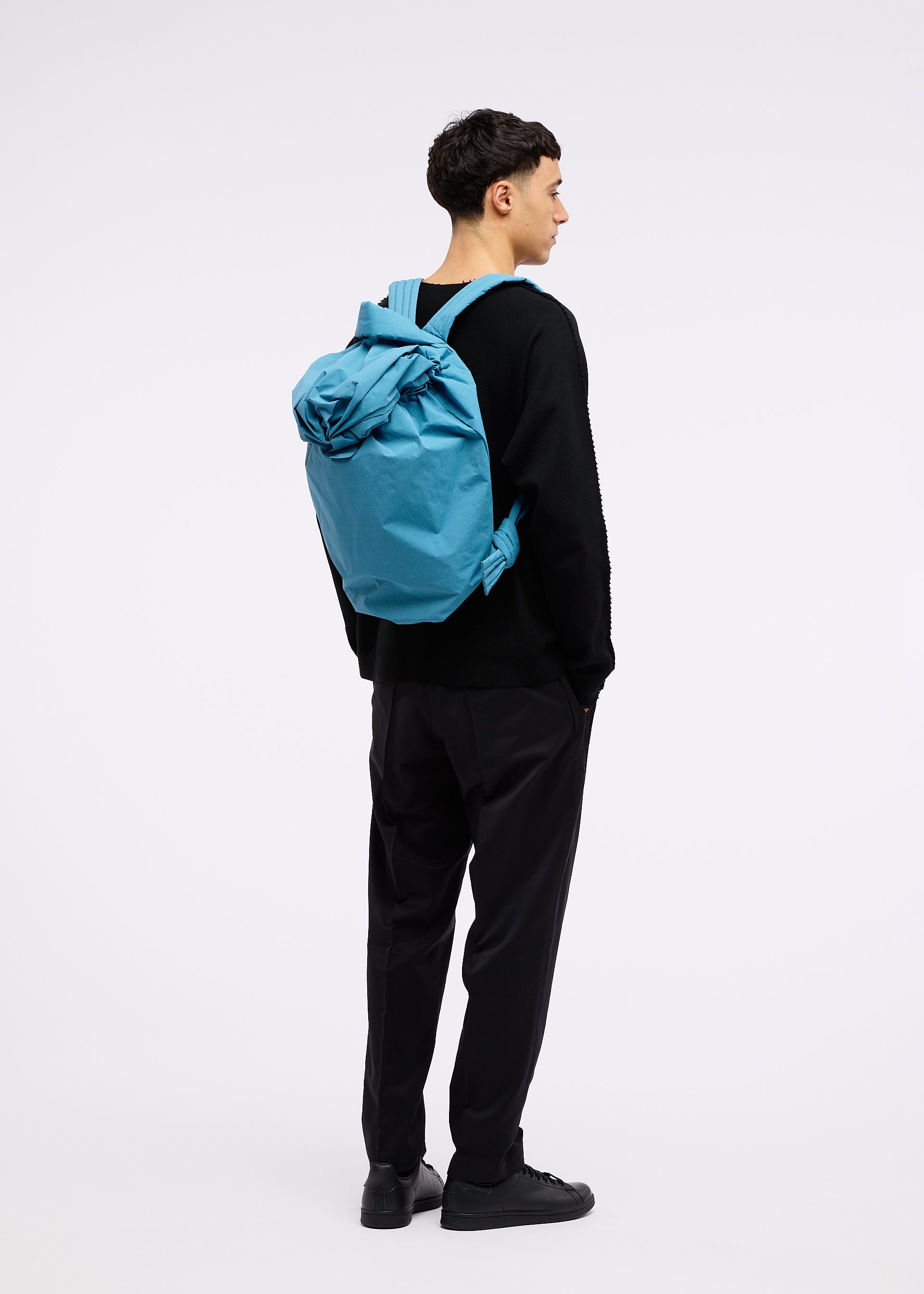 A model wears the GOOD GOODS ISSEY MIYAKE FUWA FUWA bag.