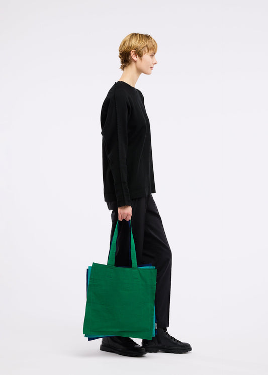 A model wears the GOOD GOODS ISSEY MIYAKE IROGAMI bag.