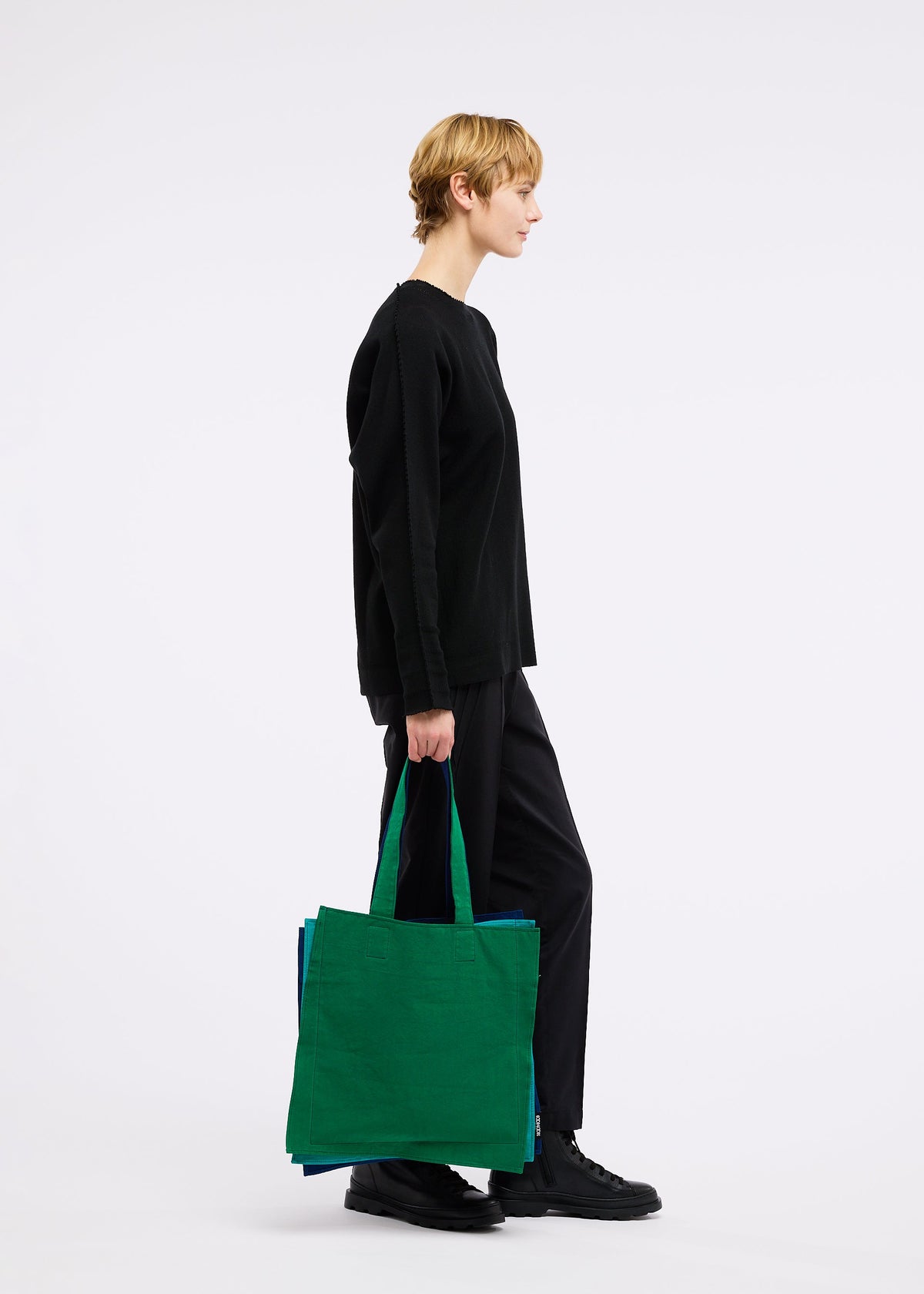 A model wears the GOOD GOODS ISSEY MIYAKE IROGAMI bag.