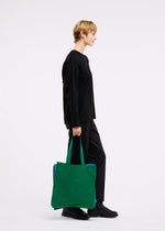 A model wears the GOOD GOODS ISSEY MIYAKE IROGAMI bag.