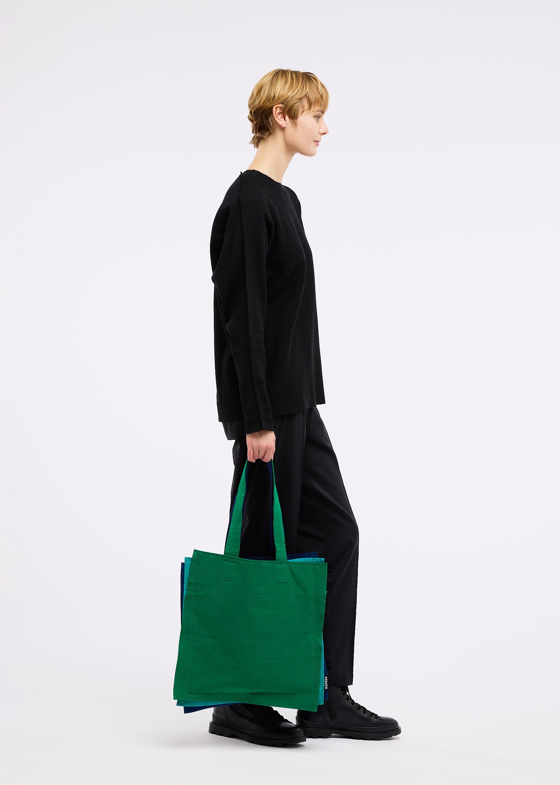 A model wears the GOOD GOODS ISSEY MIYAKE IROGAMI bag.
