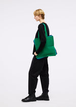 A model wears the GOOD GOODS ISSEY MIYAKE IROGAMI bag.