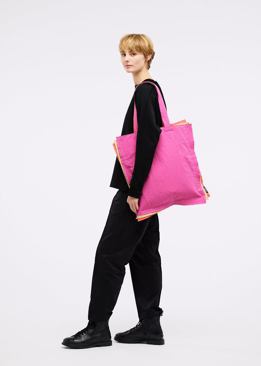 A model wears the GOOD GOODS ISSEY MIYAKE IROGAMI bag.