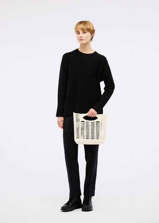 A model wears the GOOD GOODS ISSEY MIYAKE MOKKO bag.