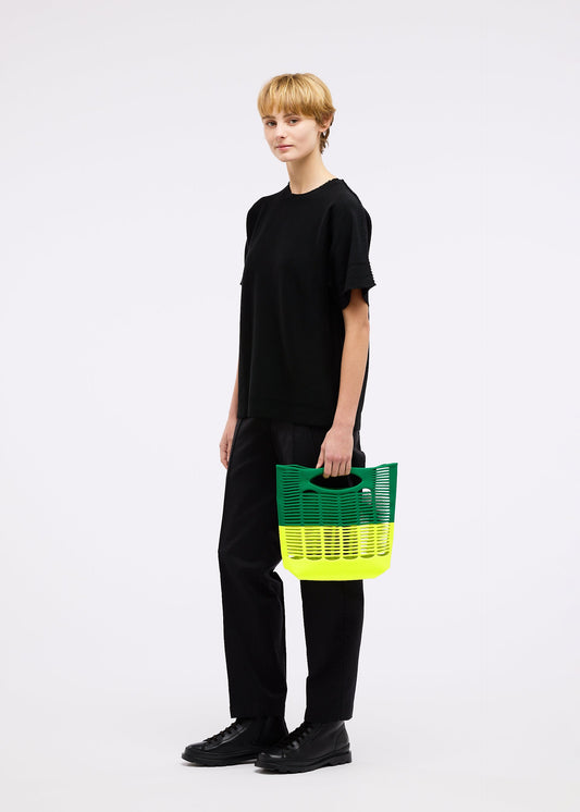 A model wears the GOOD GOODS ISSEY MIYAKE MOKKO BI COLOR bag.