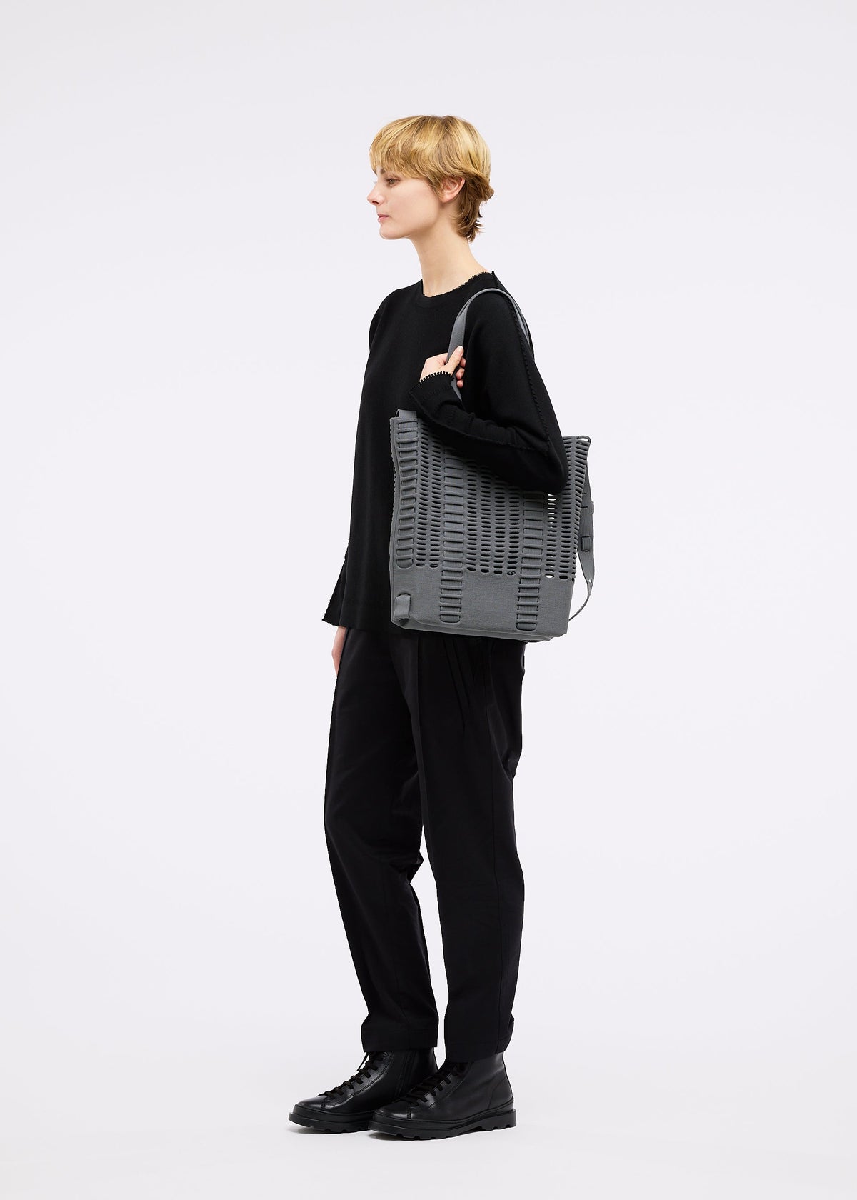 A model wears the GOOD GOODS ISSEY MIYAKE MOKKO MONO bag.