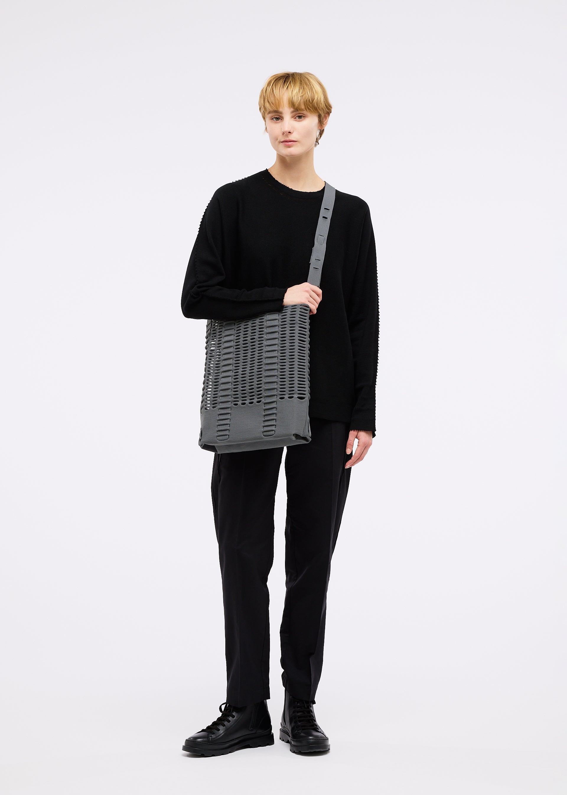 A model wears the GOOD GOODS ISSEY MIYAKE MOKKO MONO bag.