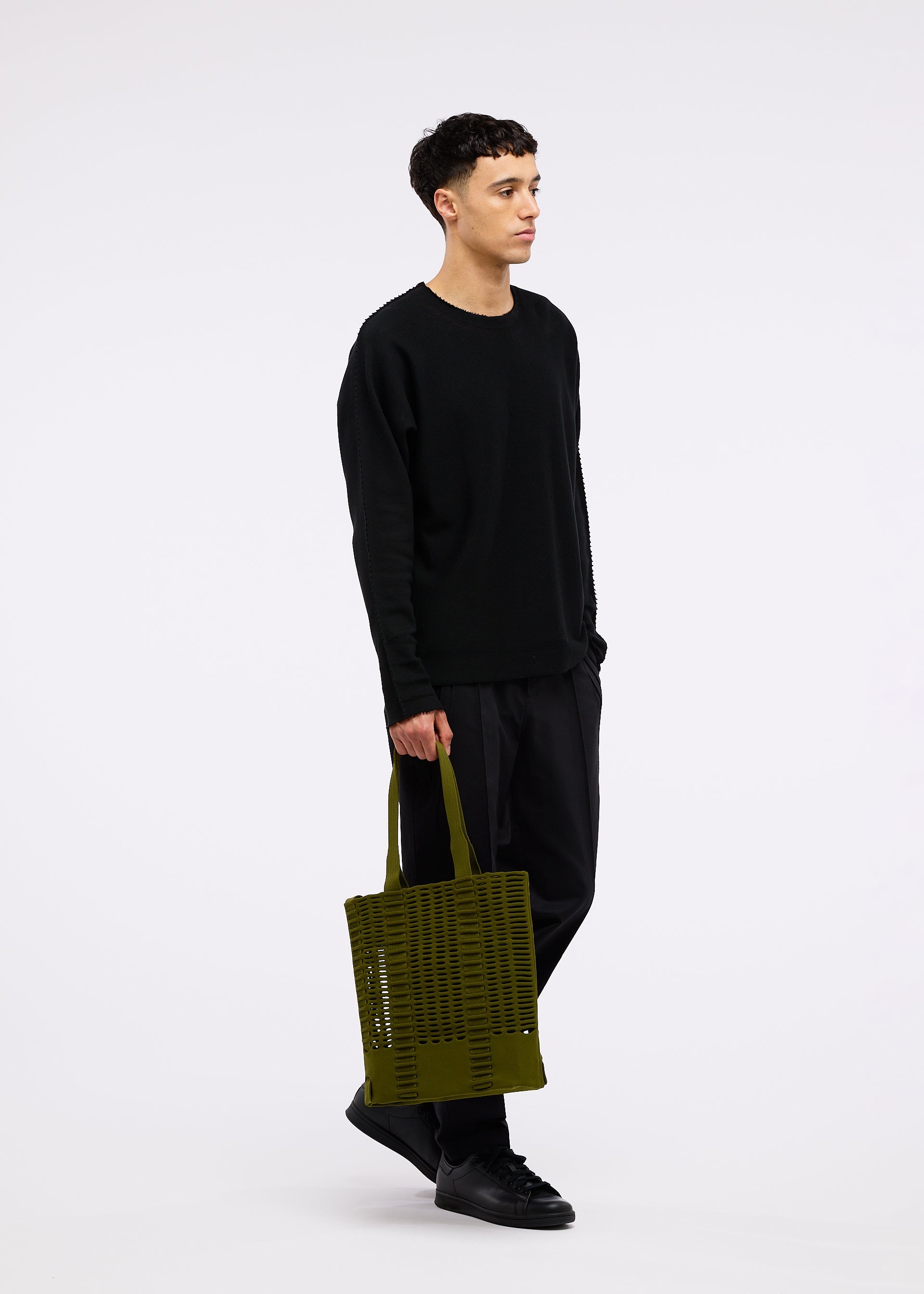 A model wears the GOOD GOODS ISSEY MIYAKE MOKKO MONO bag.
