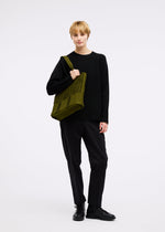 A model wears the GOOD GOODS ISSEY MIYAKE MOKKO MONO bag.