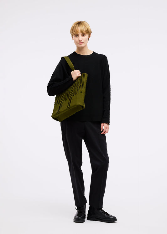A model wears the GOOD GOODS ISSEY MIYAKE MOKKO MONO bag.
