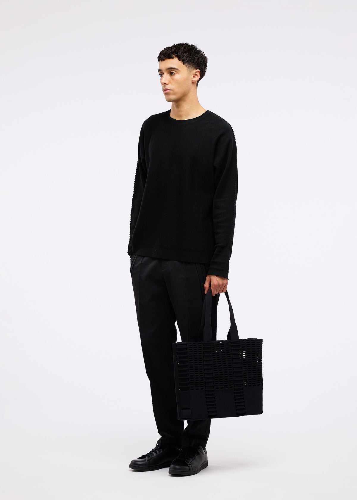 A model wears the GOOD GOODS ISSEY MIYAKE MOKKO MONO bag.