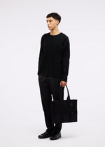 A model wears the GOOD GOODS ISSEY MIYAKE MOKKO MONO bag.