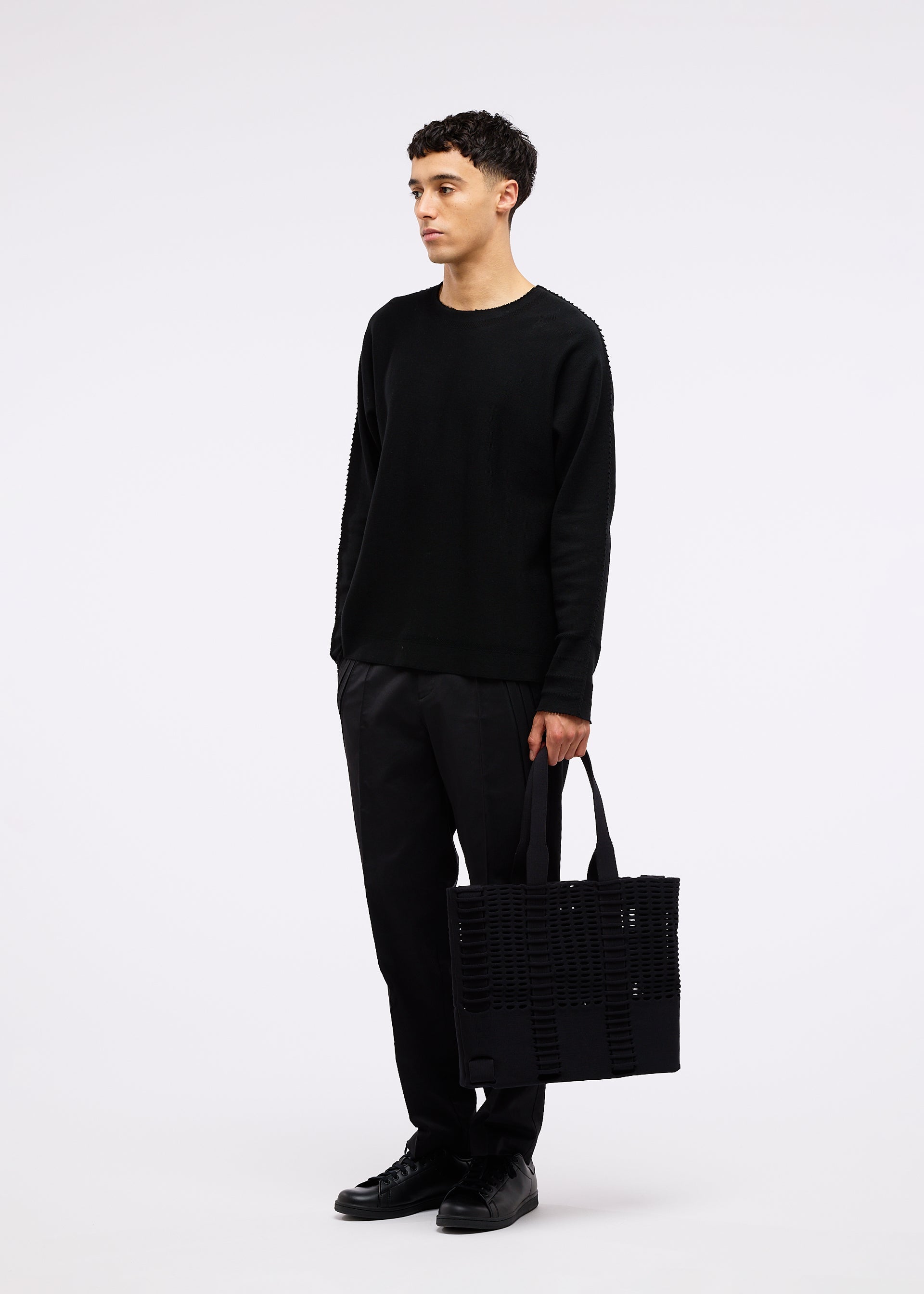 A model wears the GOOD GOODS ISSEY MIYAKE MOKKO MONO bag.