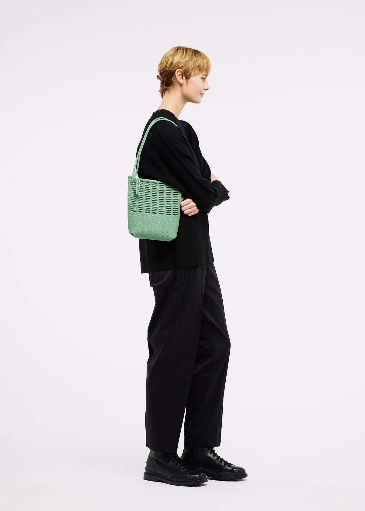 A model wears the GOOD GOODS ISSEY MIYAKE MOKKO TWILL bag.