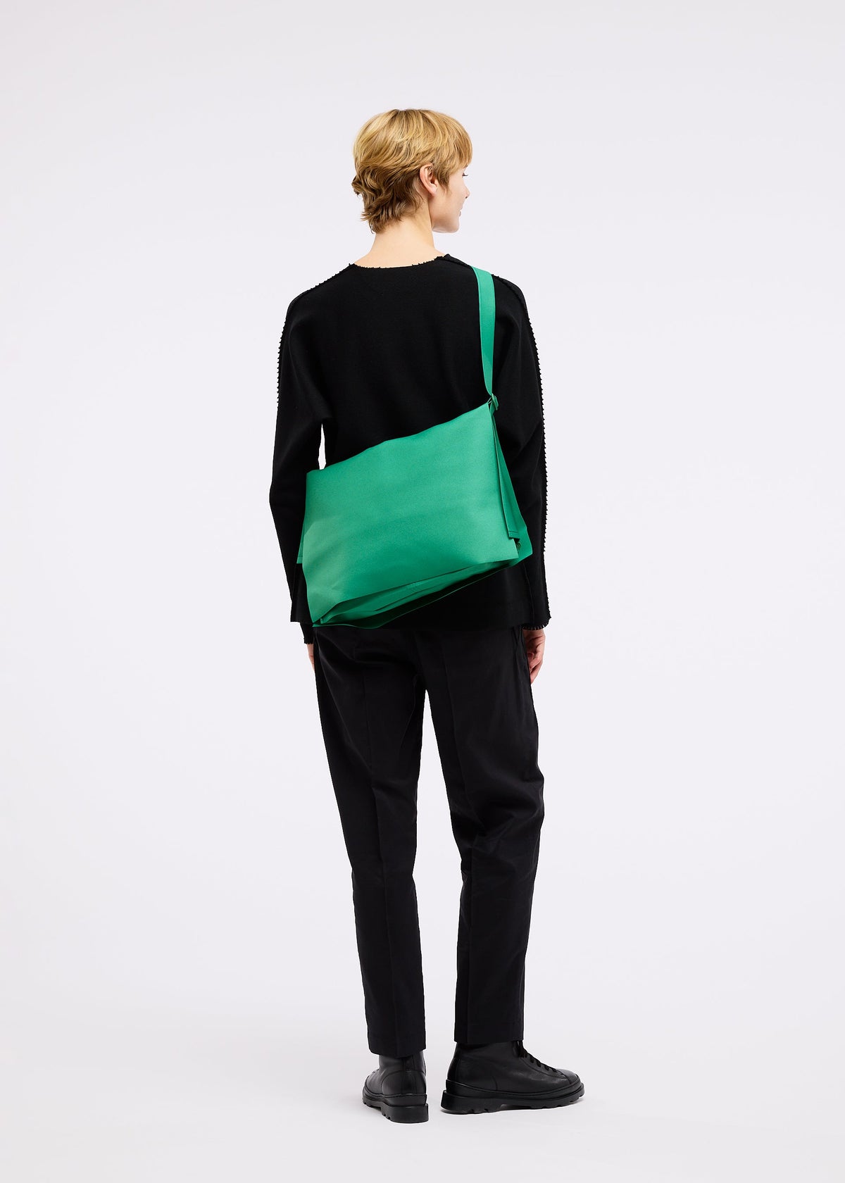 A model wears the GOOD GOODS ISSEY MIYAKE ROLL bag.