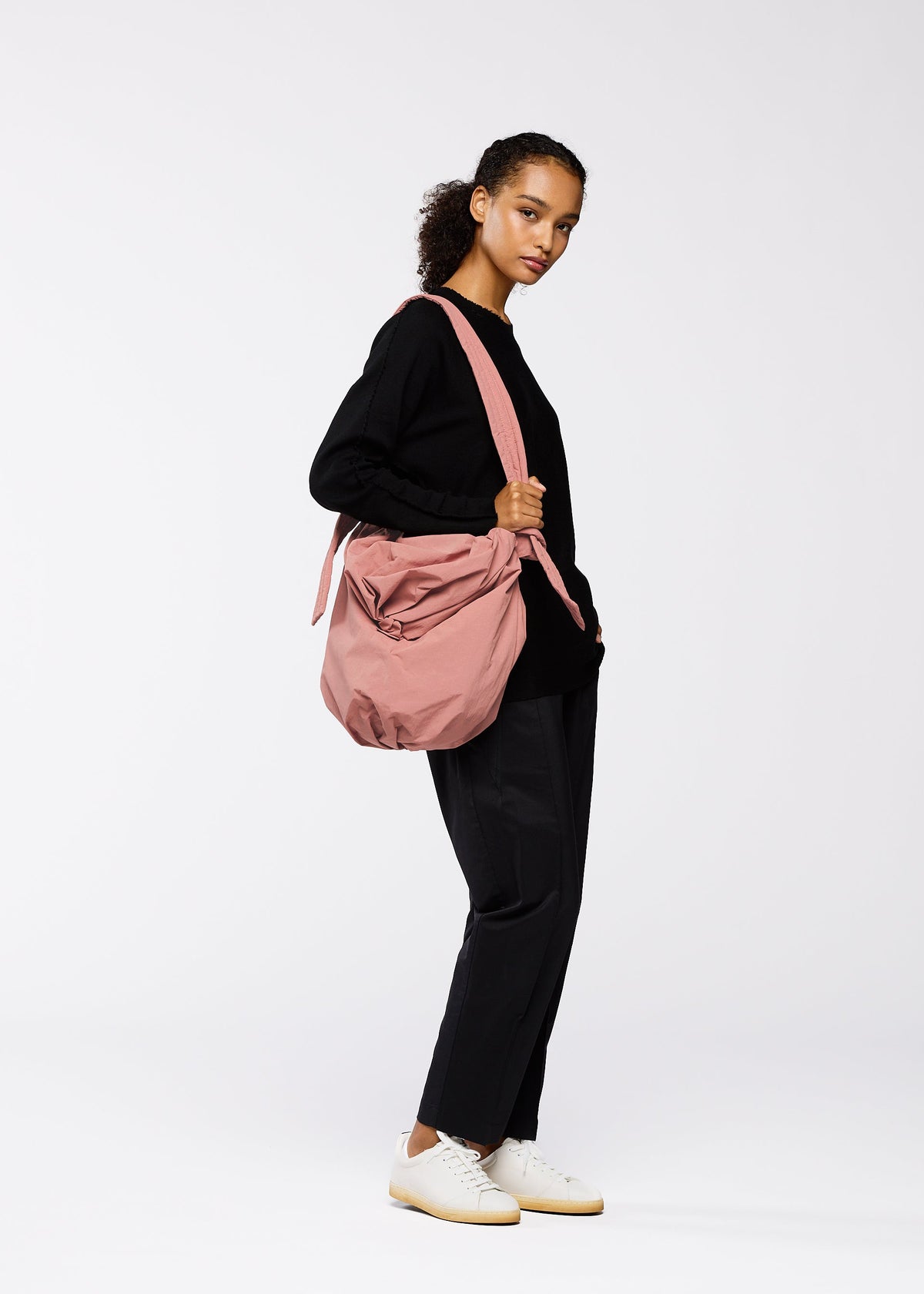 A model wears the GOOD GOODS ISSEY MIYAKE FUWA FUWA bags.