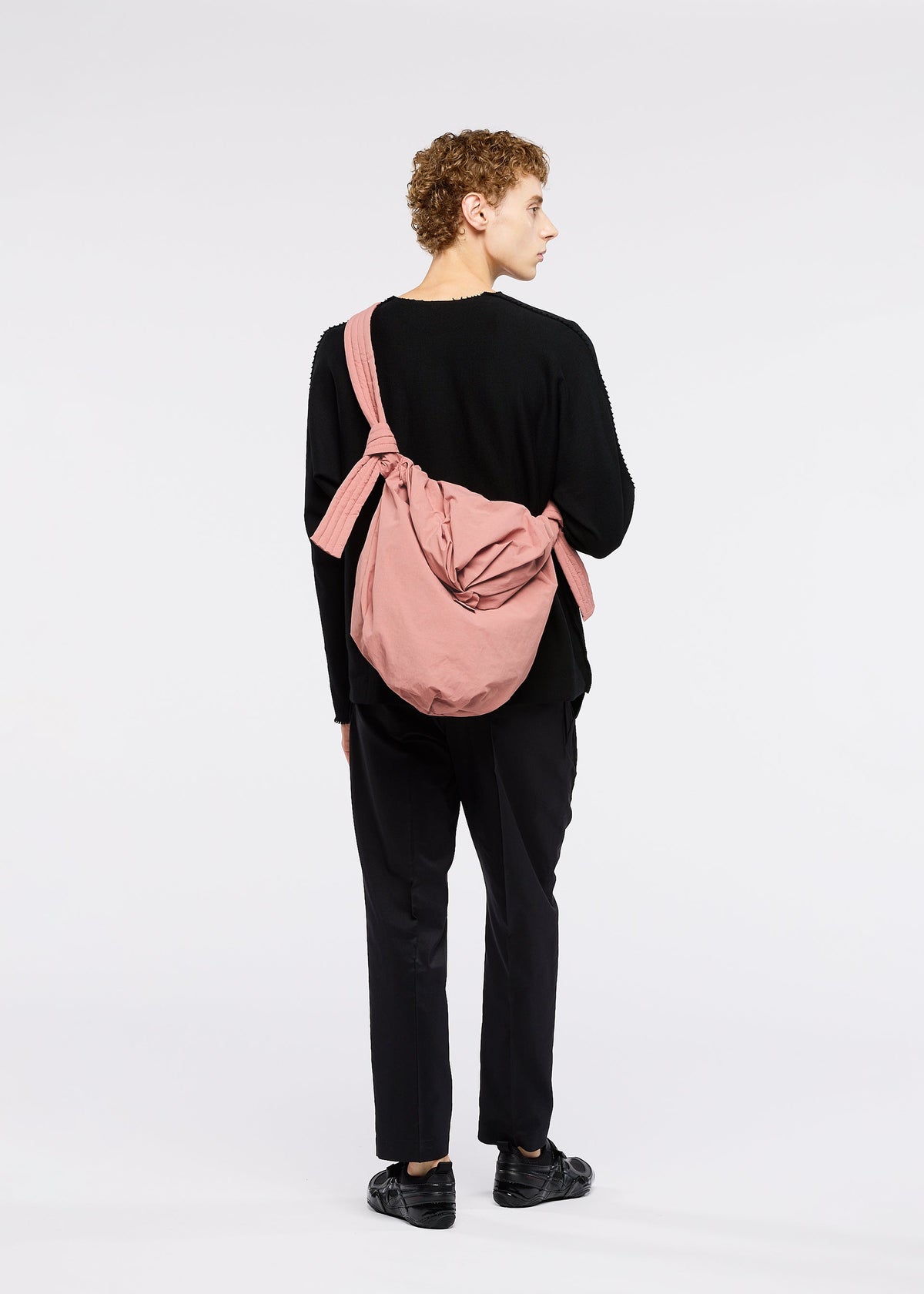 A model wears the GOOD GOODS ISSEY MIYAKE FUWA FUWA bags.