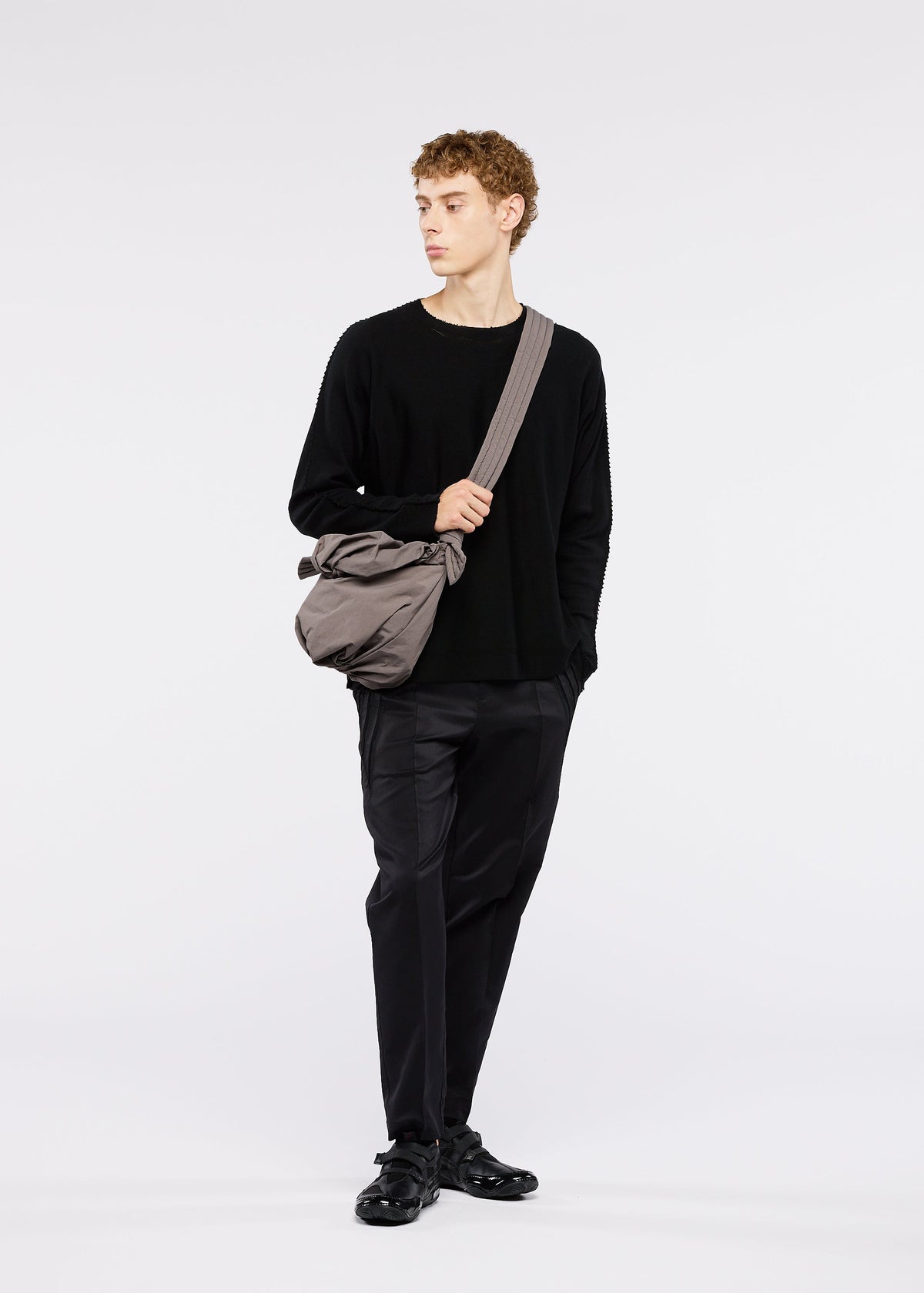 A model wears the GOOD GOODS ISSEY MIYAKE FUWA FUWA bags.