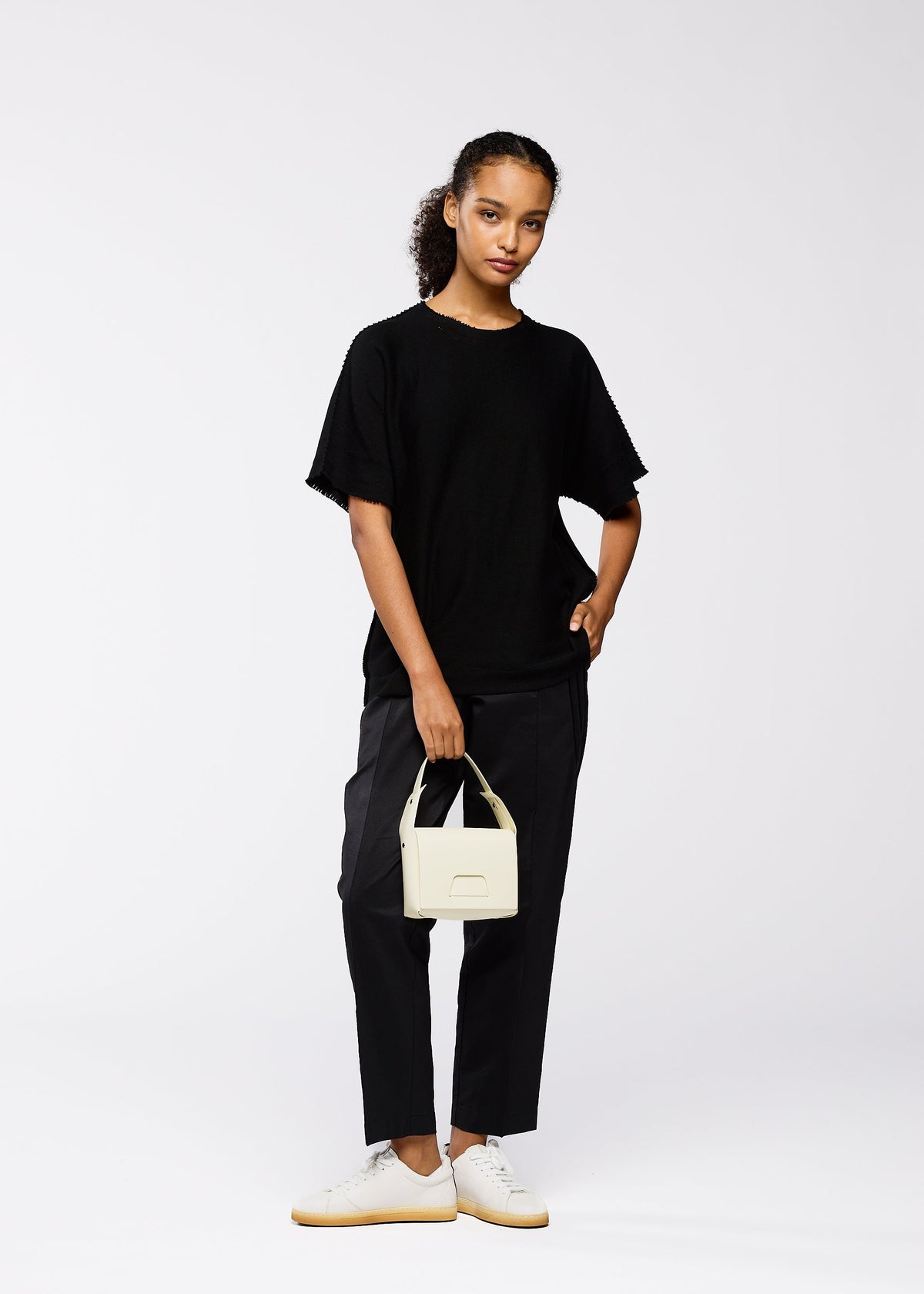 A model wears the GOOD GOODS ISSEY MIYAKE BOX bag.