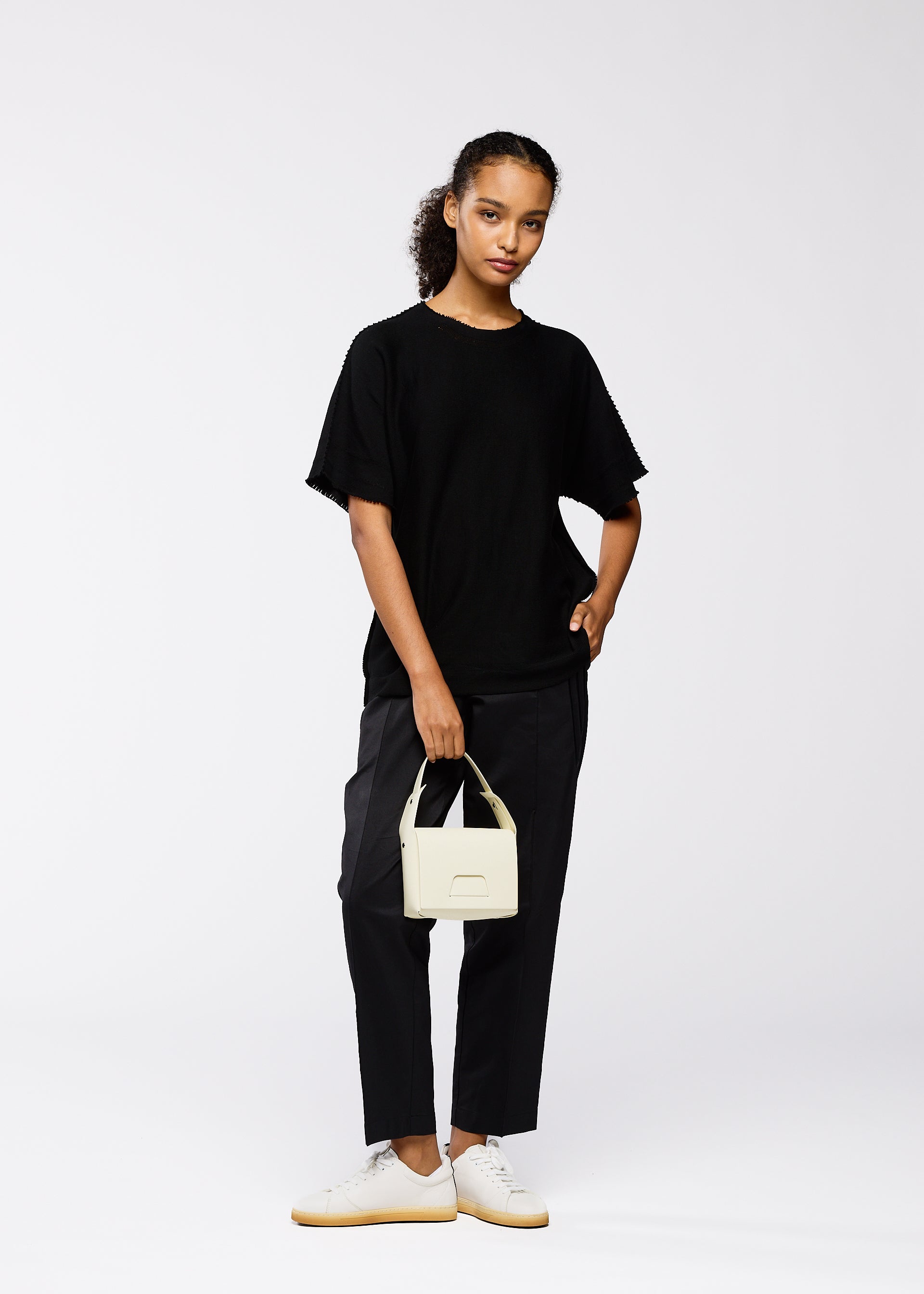 A model wears the GOOD GOODS ISSEY MIYAKE BOX bag.