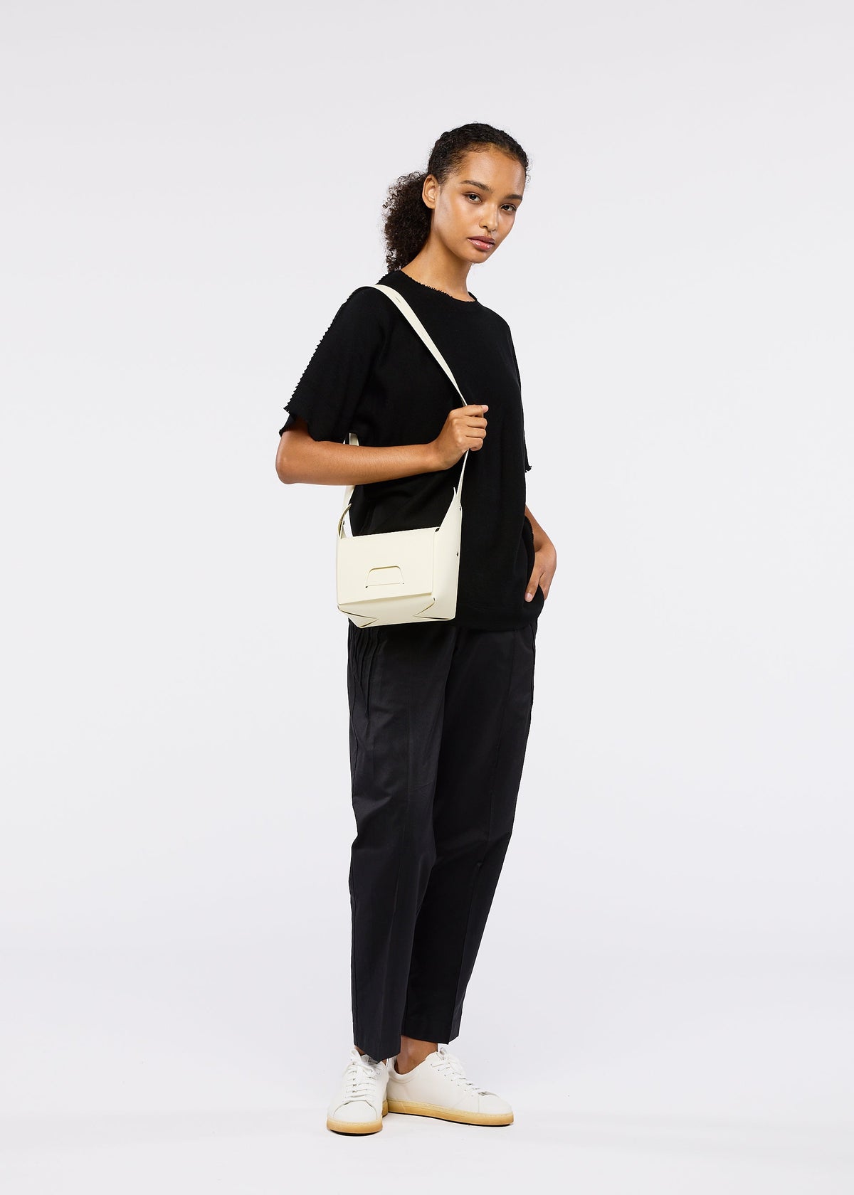 A model wears the GOOD GOODS ISSEY MIYAKE BOX bag.