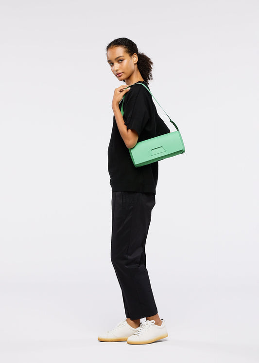 A model wears the GOOD GOODS ISSEY MIYAKE BOX bag.