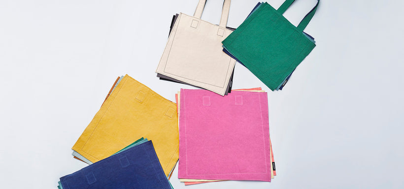 Centre: IROGAMI Totes in White Mix, Pink Mix, Yellow Mix and Green Mix laid flat against a light grey background.