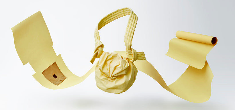 Centre: FUWA FUWA shoulder bag in Light Yellow, displayed with its pattern and a roll of fabric, suspended mid-air against a white background.