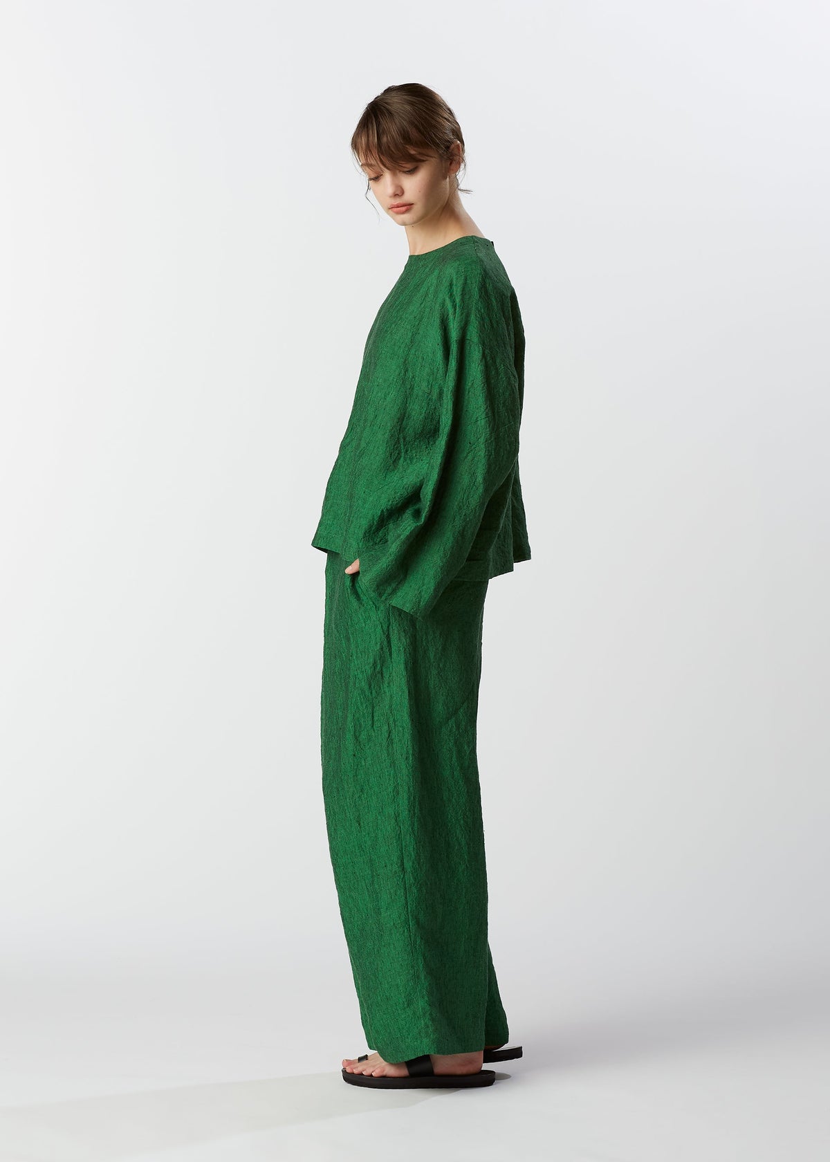 A model wears the HAAT GLOSSY LINEN trousers.