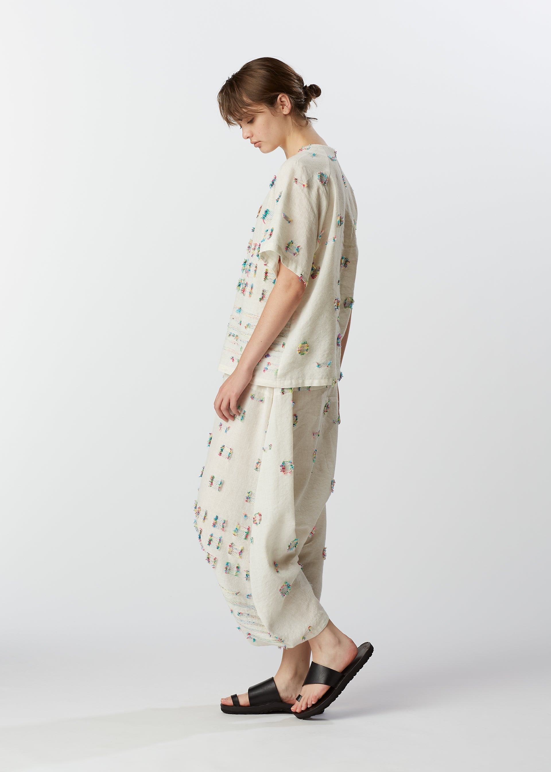 A model wears the HAAT KOMOREBI trousers.