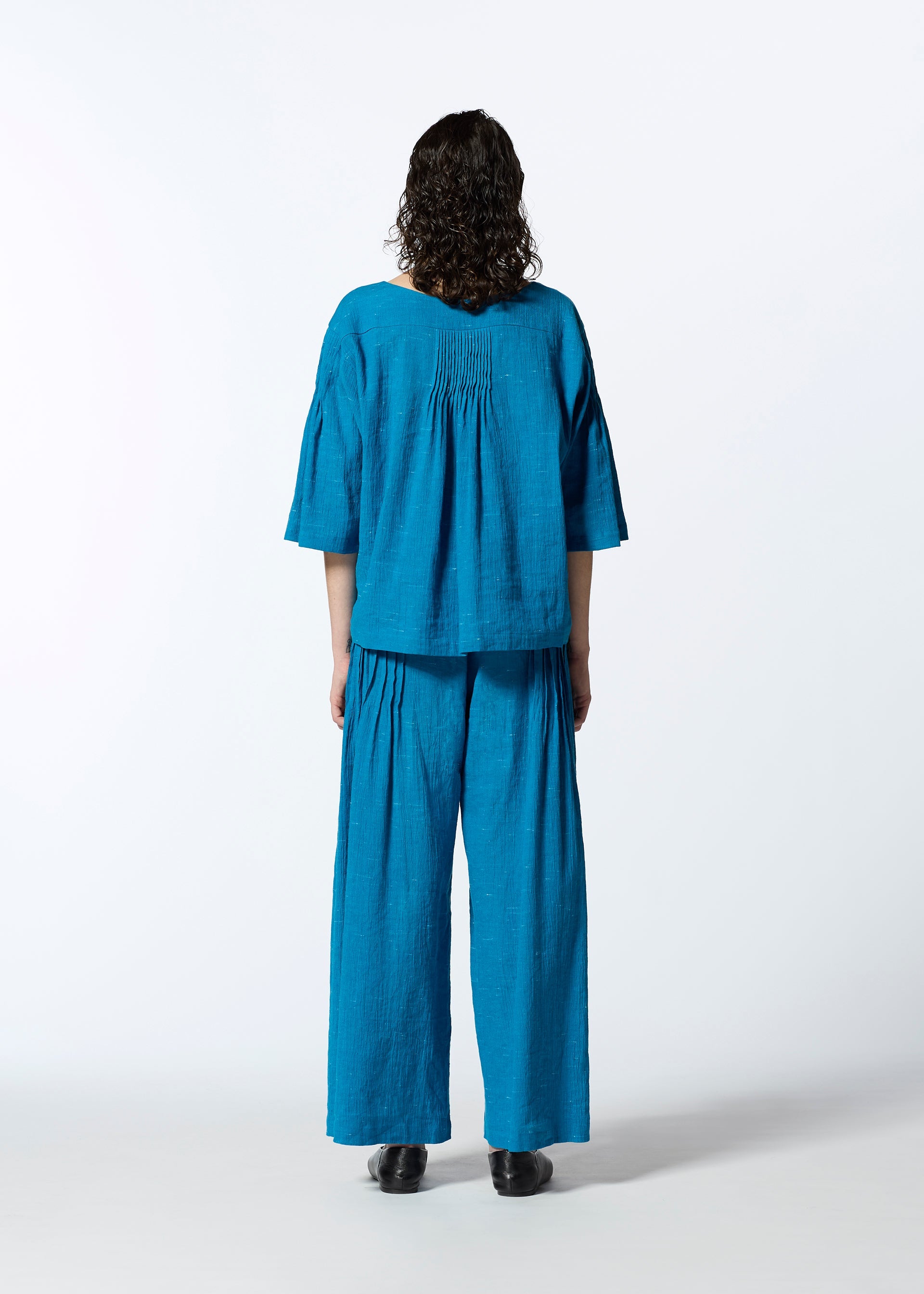 A model wears the HAAT PINTUCKING trousers.