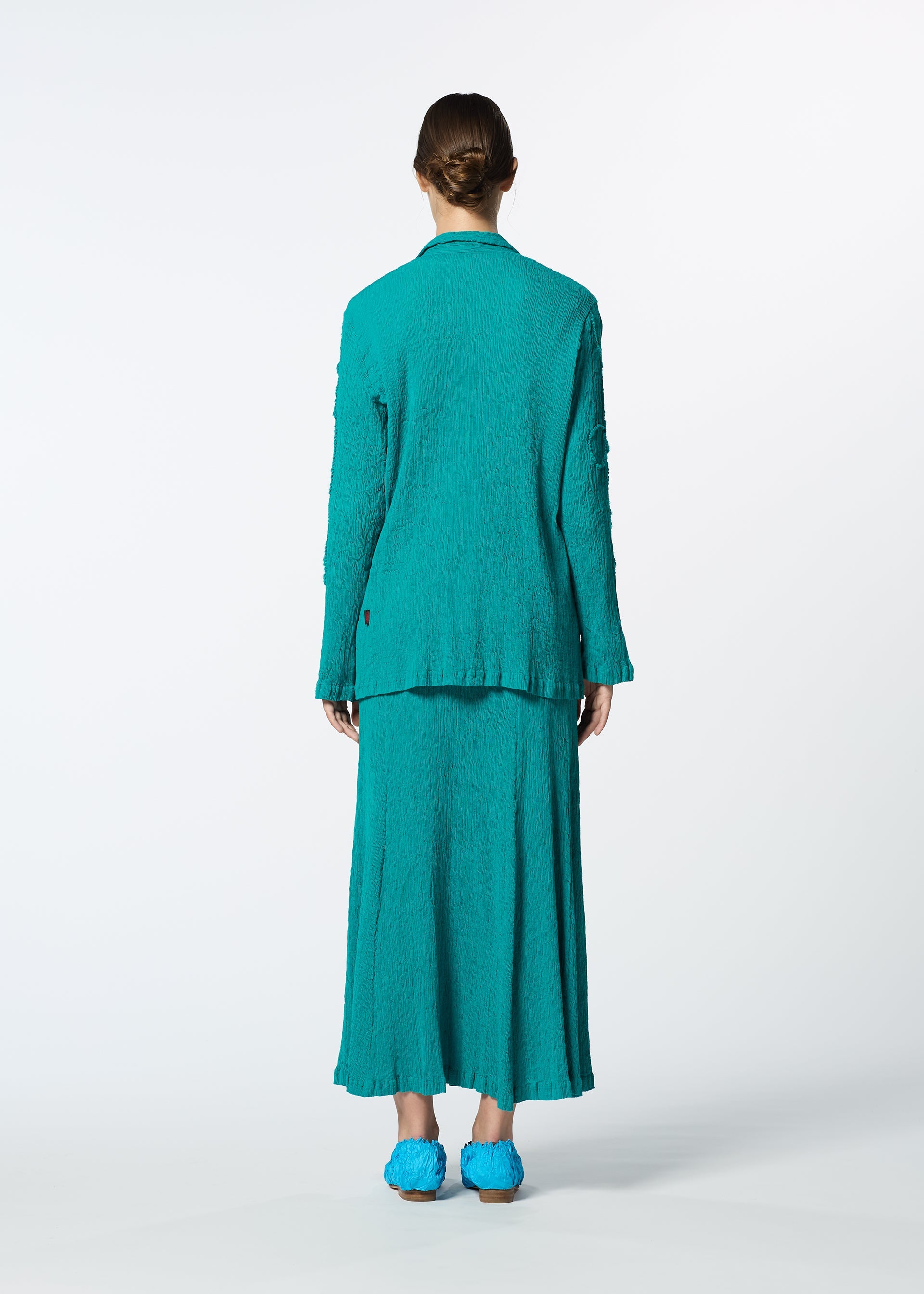 A model wears the HAAT KYO CHIJIMI EMB skirt.