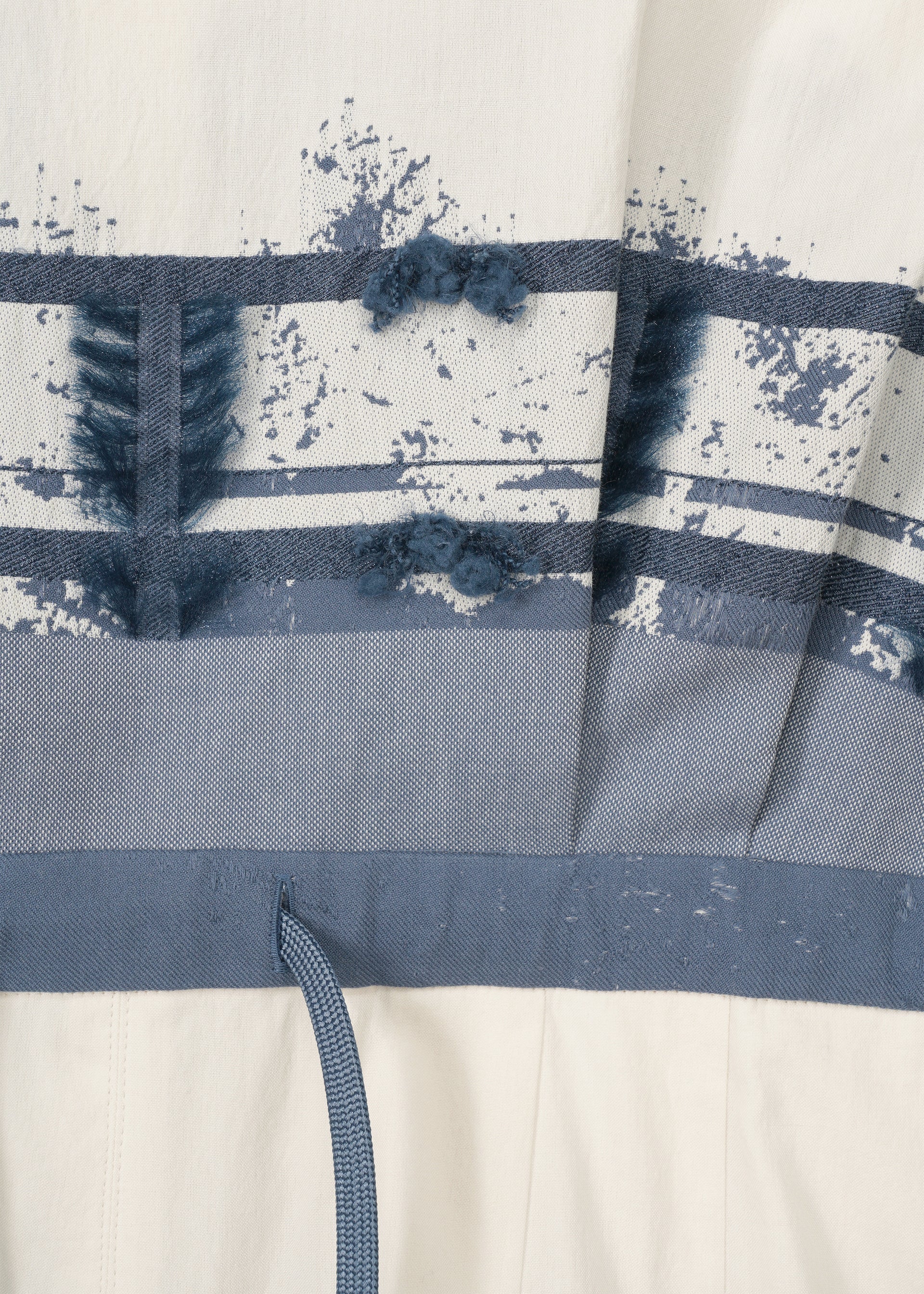 A detail shot of the HAAT KASANEGAKE jumpsuit.