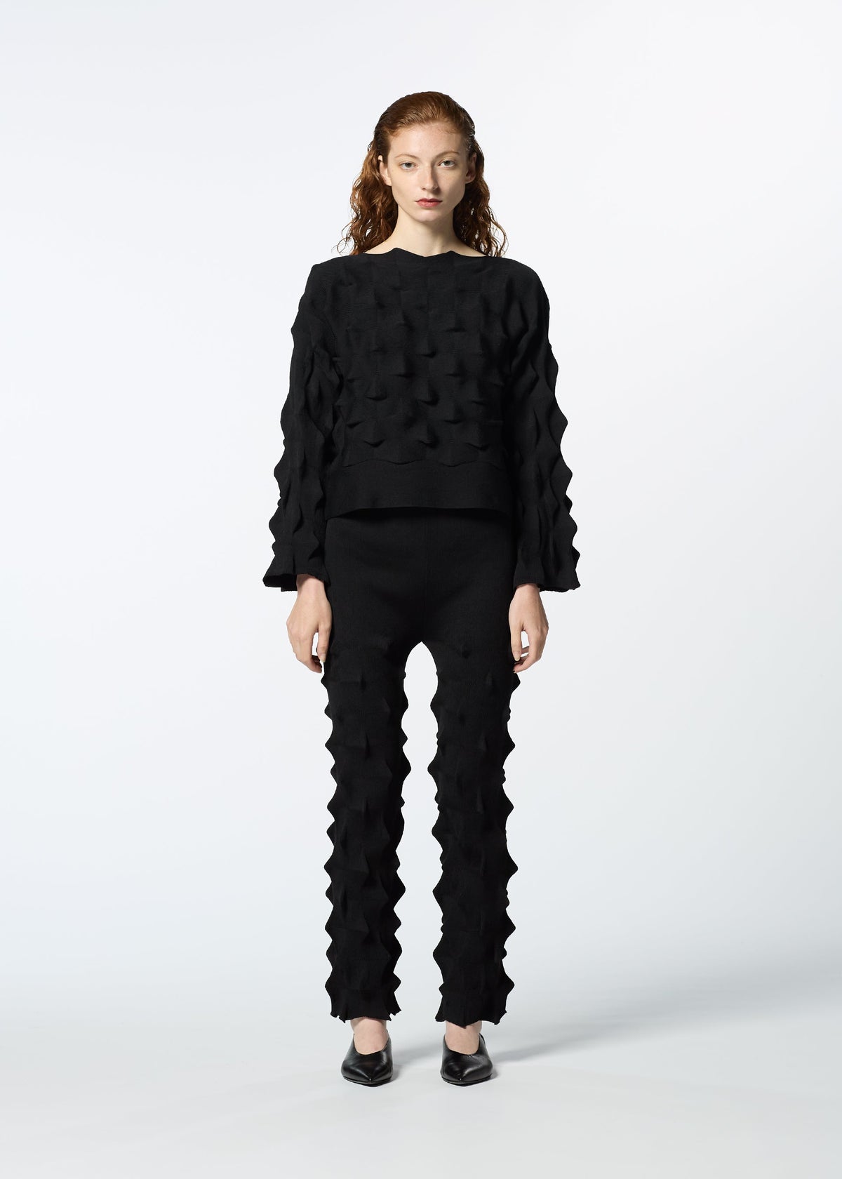 A model wears the HAAT ZIG ZAG KNIT trousers.