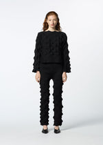 A model wears the HAAT ZIG ZAG KNIT trousers.