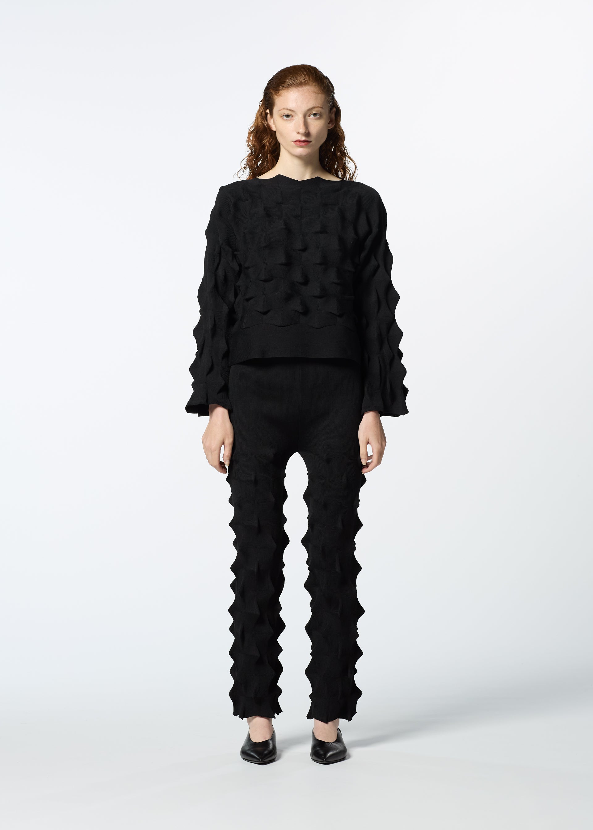 A model wears the HAAT ZIG ZAG KNIT trousers.