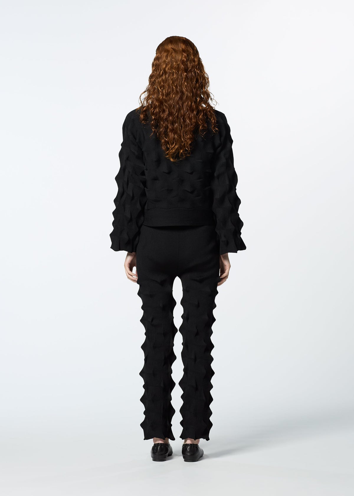 A model wears the HAAT ZIG ZAG KNIT trousers.