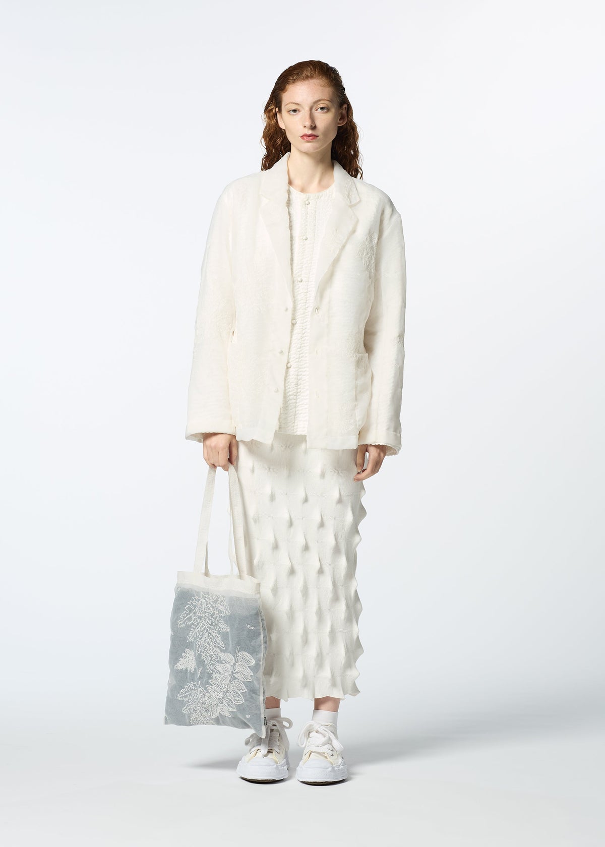 A model wears the HAAT GLASSLEAF TOTE JANUARY bags.